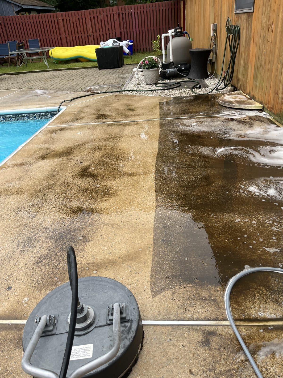 Pressure washing progress on a pool deck — half cleaned, half dirty